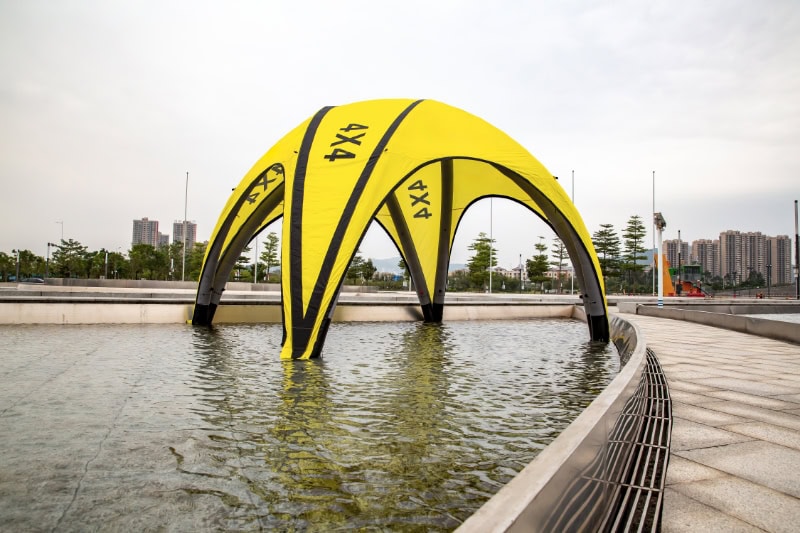 Yellow inflatable arch over urban water feature