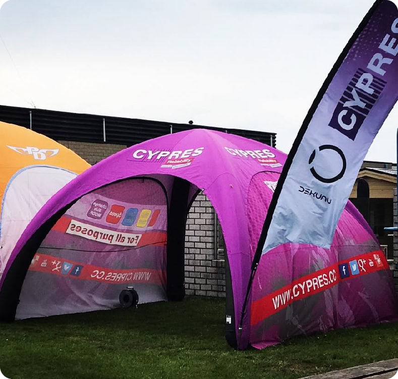 Full-print inflatable dome with teardrop flag at a skydiving brand event